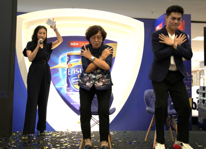 Caregiver and content creator Alvin and Ah Ma attempting the Ensure Stand4Strength challenge - proving that with good muscle health, young and senior Malaysians can pursue their interests with ease. 