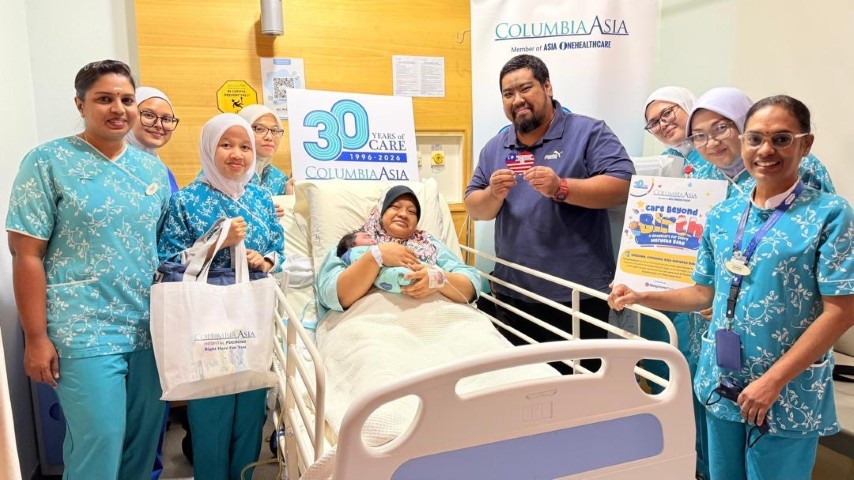 Norhaniza Binti Mohamad Osman (centre) holds her newborn son, who was born on Merdeka Day at Columbia Asia Hospital Puchong, alongside her husband Ahmad Asyroor bin Mohd Kamil and the hospital team
